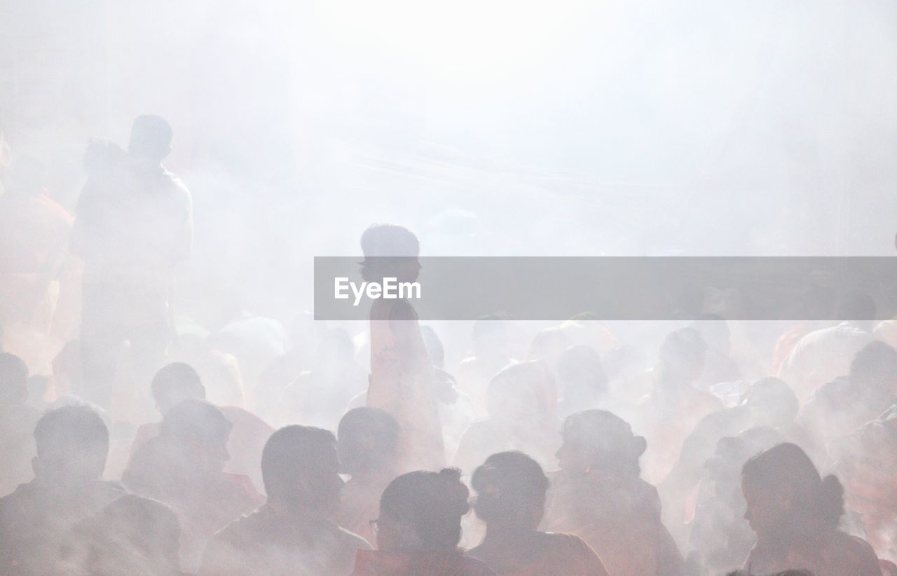 A girl standing inside croud in rakher upobash in a smokey environment at rakher upobash 