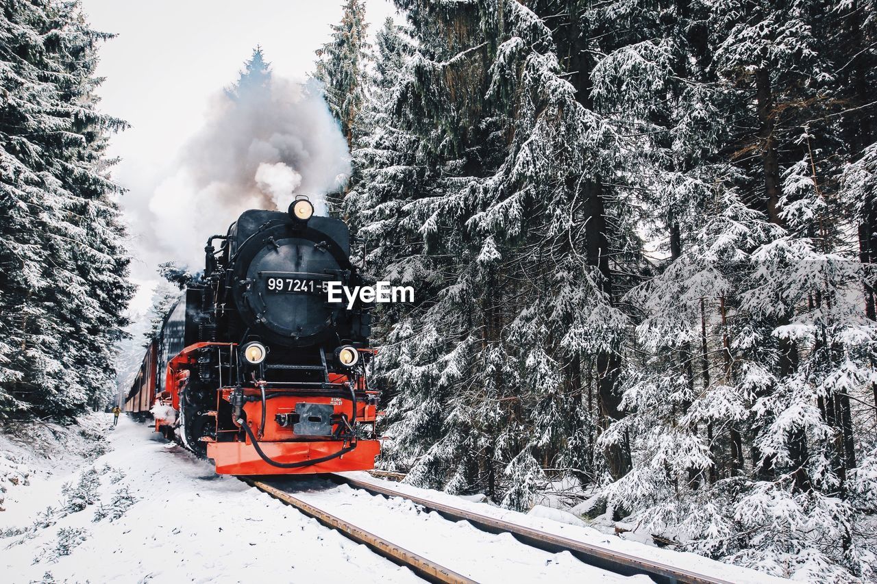 Steam train on railroad track during winter