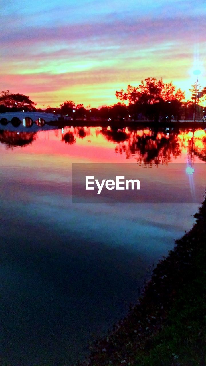 SILHOUETTE TREES BY LAKE AGAINST SKY DURING SUNSET