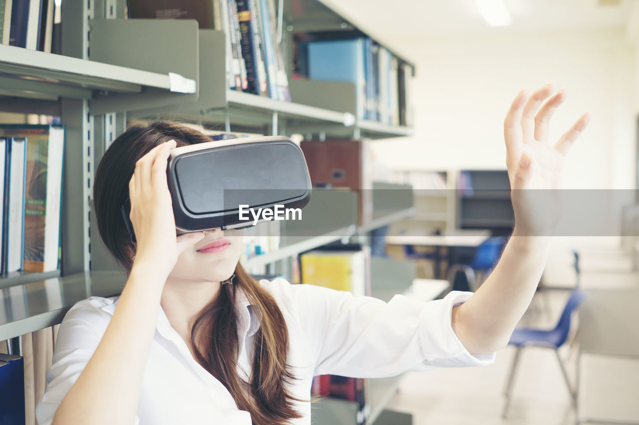 Female student using virtual reality simulator in library