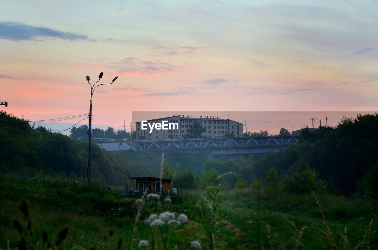 Scenic view of city against sky at sunset