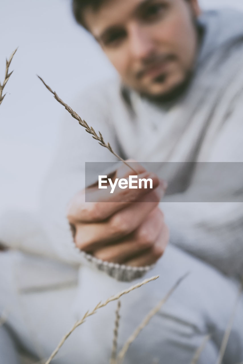 Midsection of man holding straw