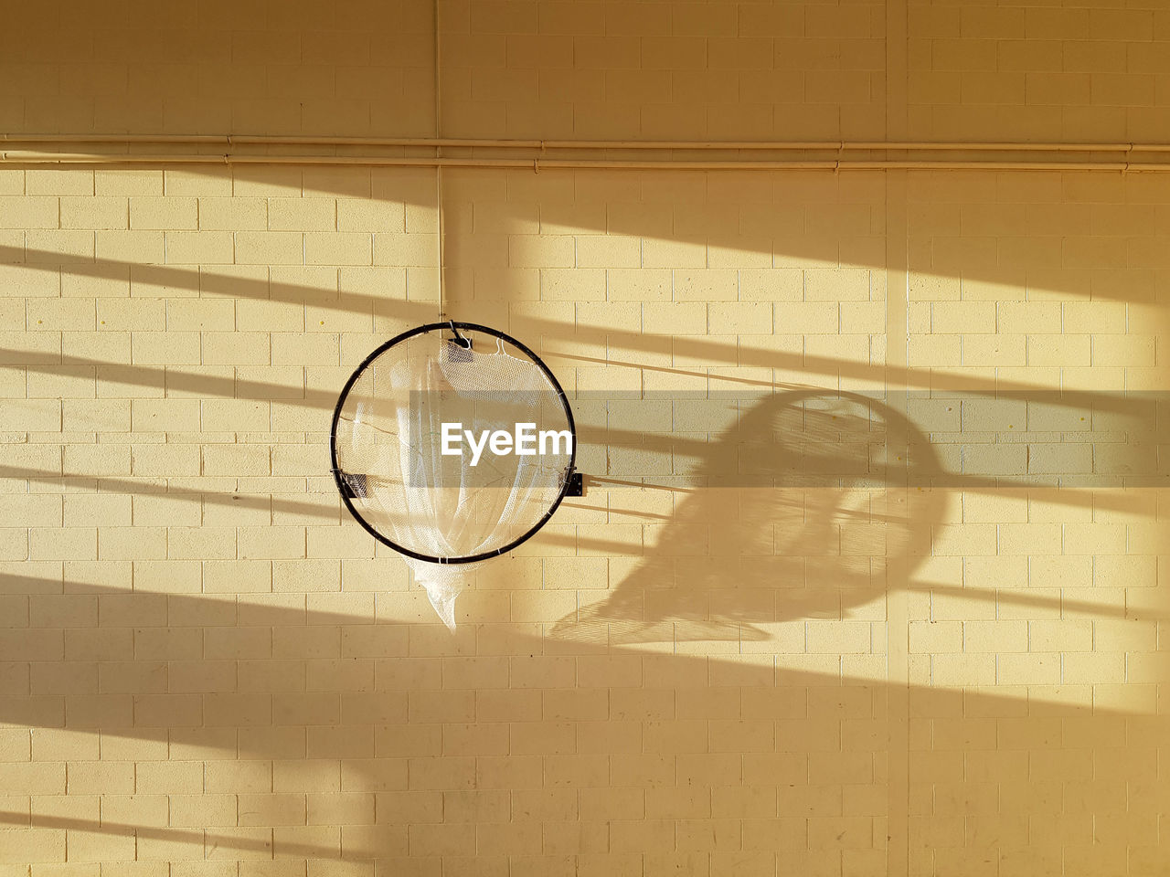 Ball hoop in school sports hall with shadows on wall