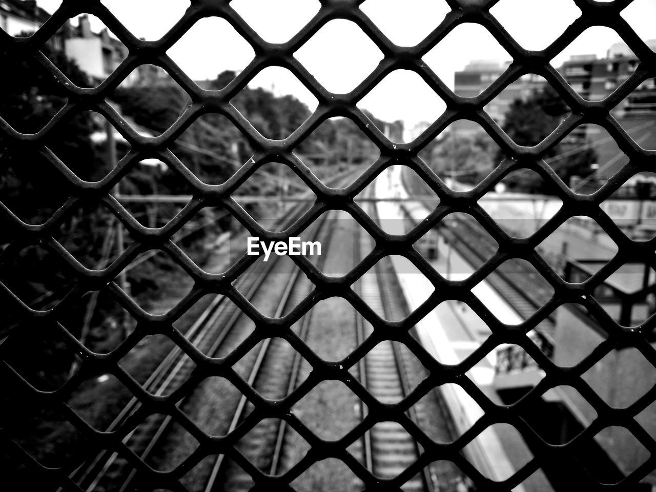 Railroad tracks seen through chainlink fence