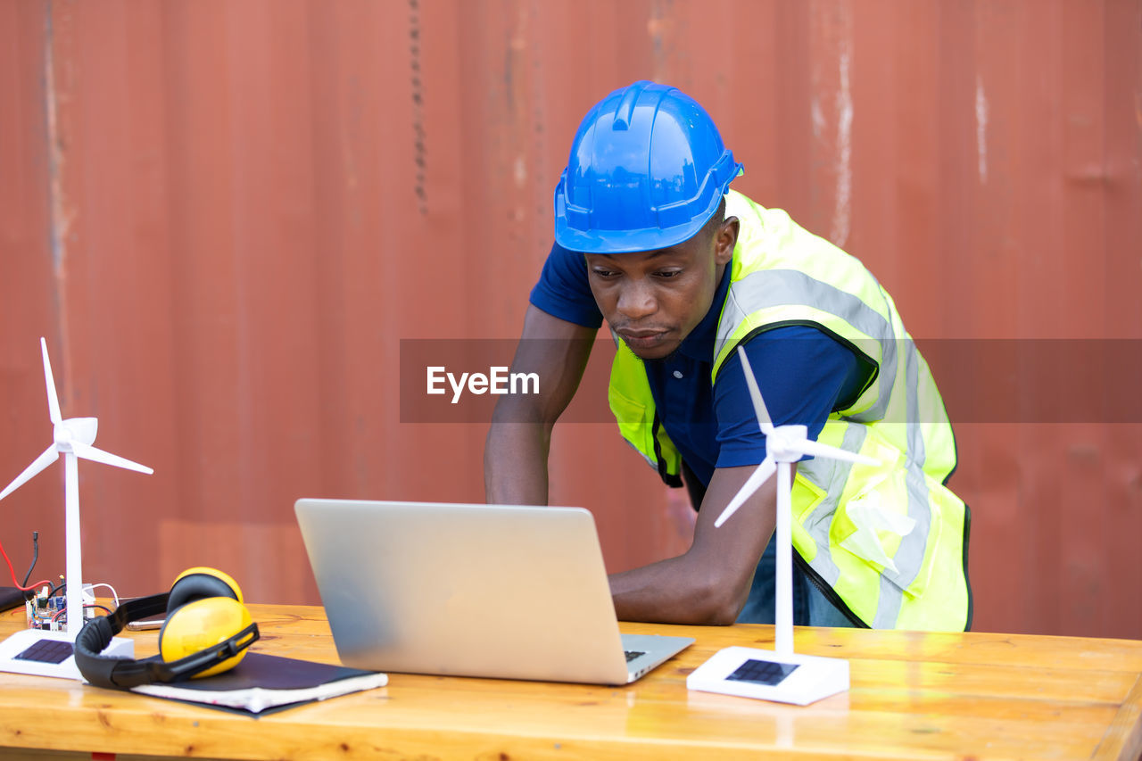 MAN WORKING WITH LAPTOP IN TABLE