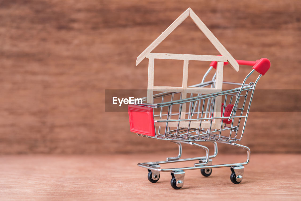 Close-up of model home in shopping cart on table