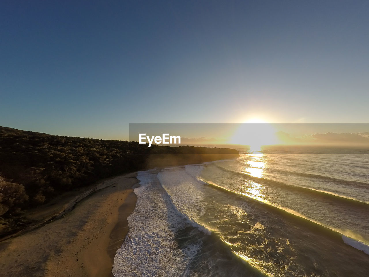 Scenic view of frozen lake against clear sky during sunset