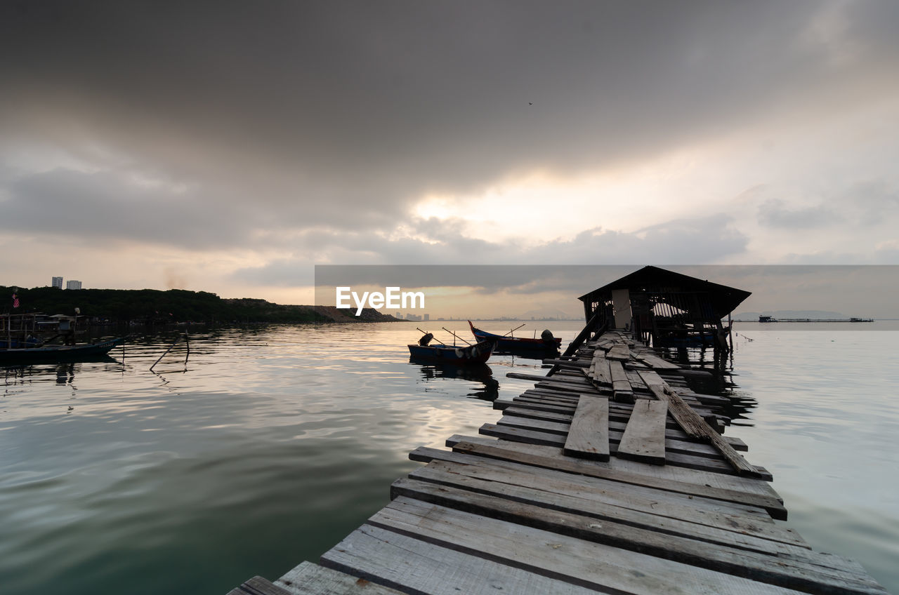 water, sky, cloud, sea, nature, pier, reflection, wood, sunset, nautical vessel, ocean, architecture, vehicle, scenics - nature, beauty in nature, tranquility, jetty, transportation, coast, shore, tranquil scene, beach, built structure, outdoors, land, travel destinations, no people, travel, dock, dusk, evening, boat, wave, environment, horizon, silhouette, landscape, mode of transportation, sunlight