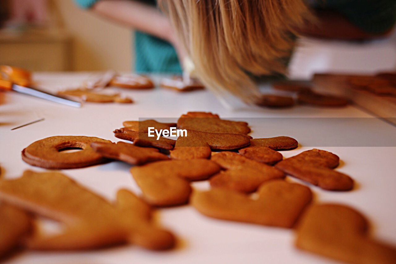 Midsection of girl decorating gingerbread cookies on table