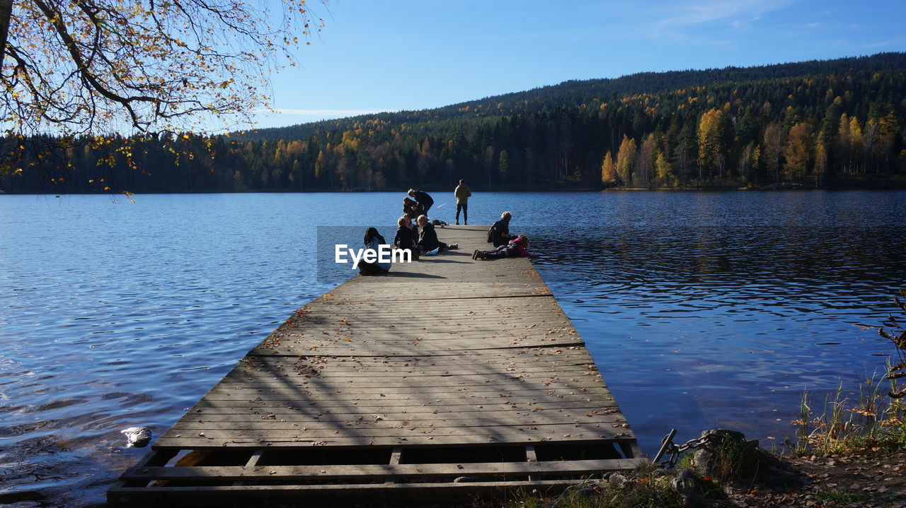 People on jetty over river