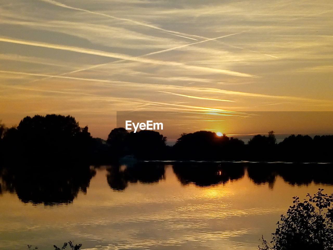 SILHOUETTE TREES BY LAKE AGAINST SKY DURING SUNSET