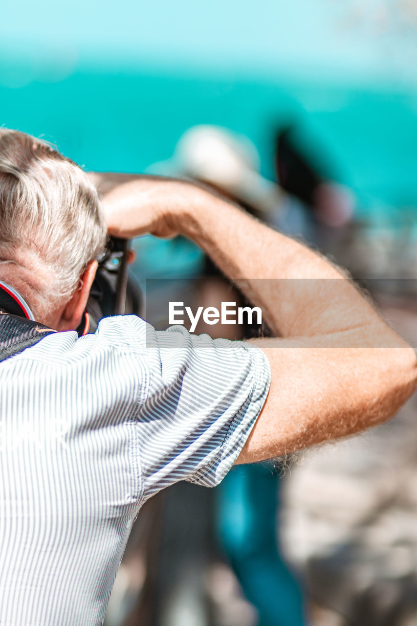 Rear view of man photographing outdoors