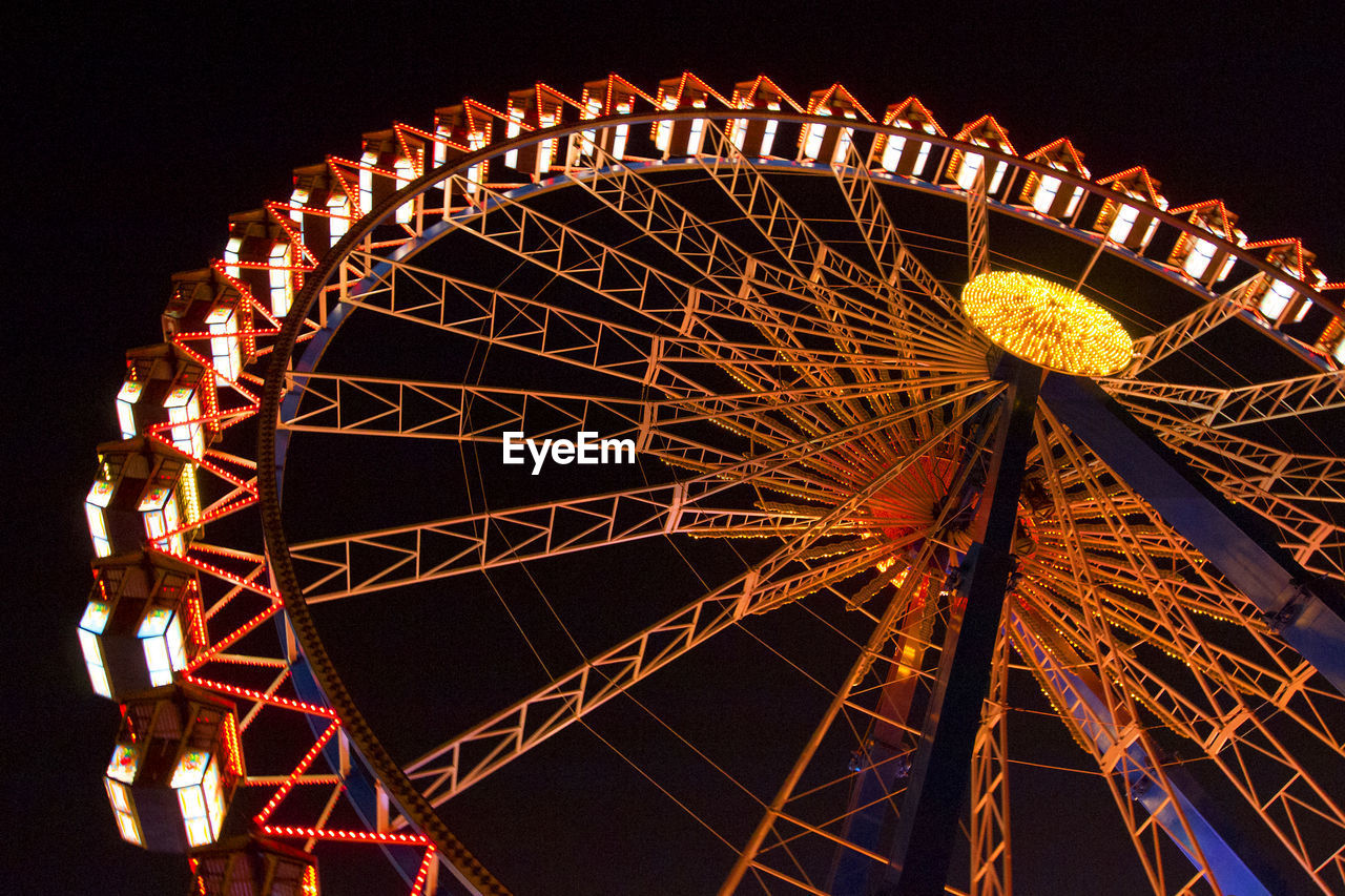 low angle view of illuminated ferris wheel against clear sky at night