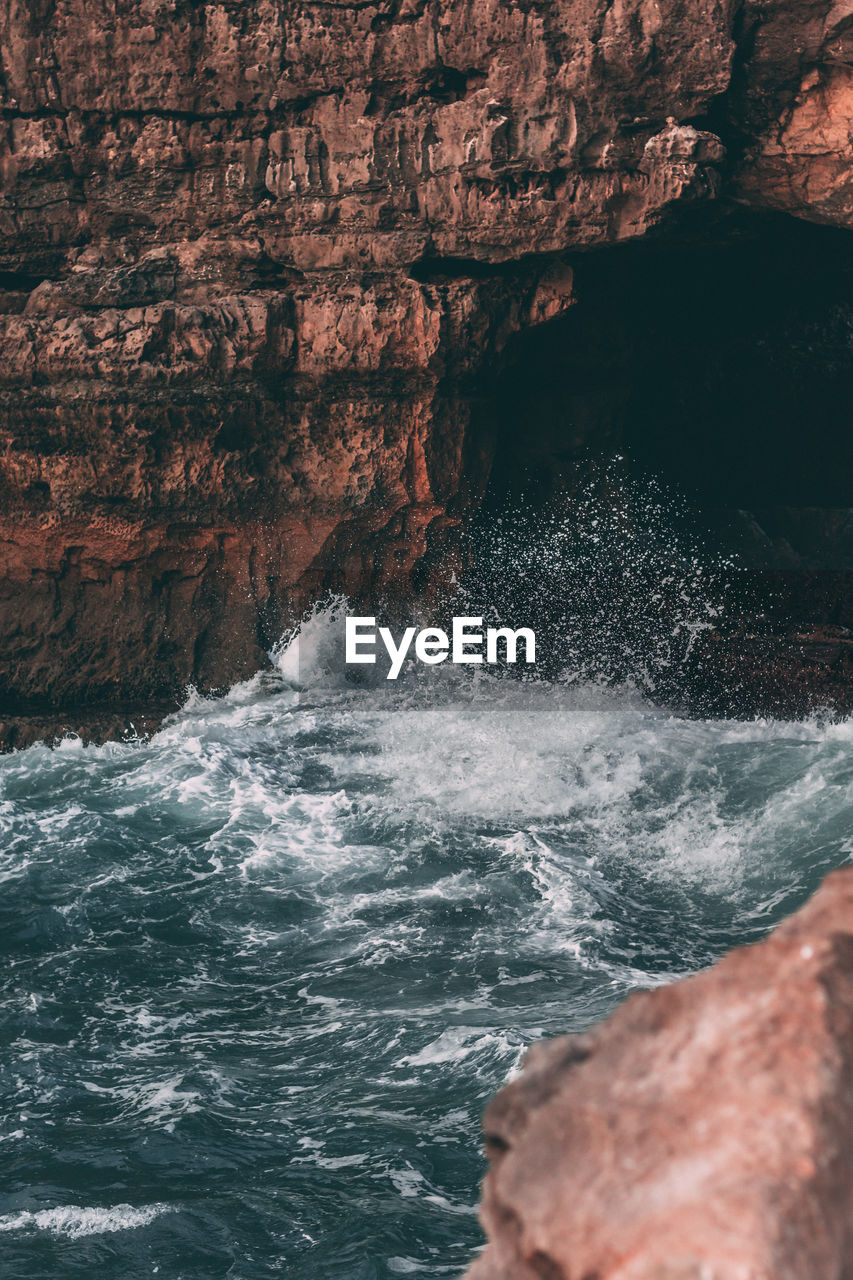 Scenic view of sea against rock formation