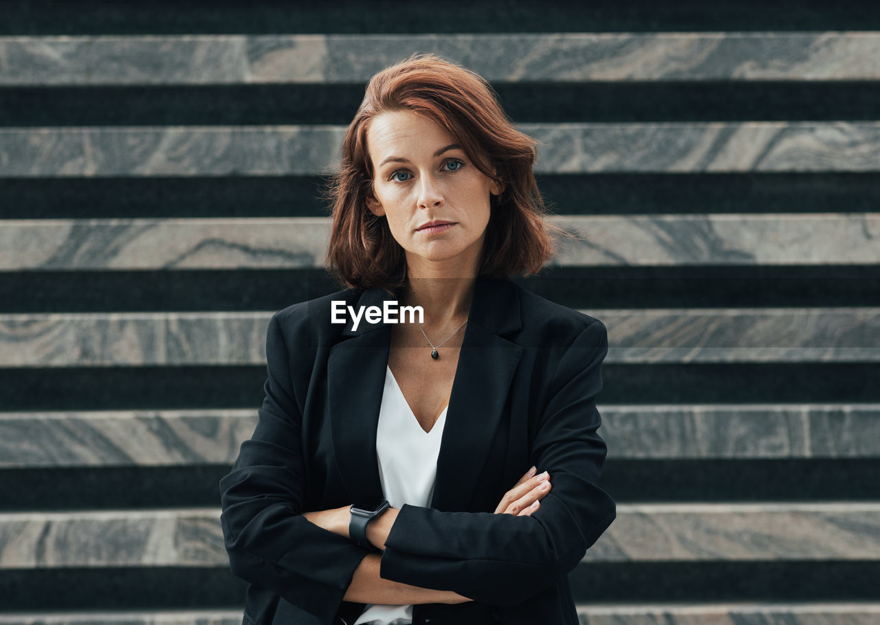 portrait of young woman looking away while standing on steps