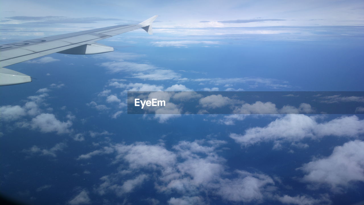 Aerial view of cloudscape over airplane wing