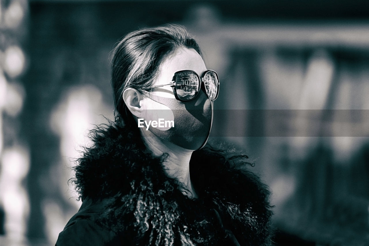 PORTRAIT OF YOUNG WOMAN WEARING SUNGLASSES