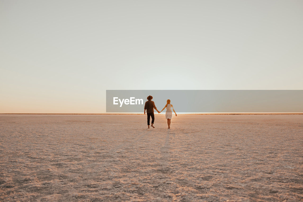 rear view of woman walking at beach
