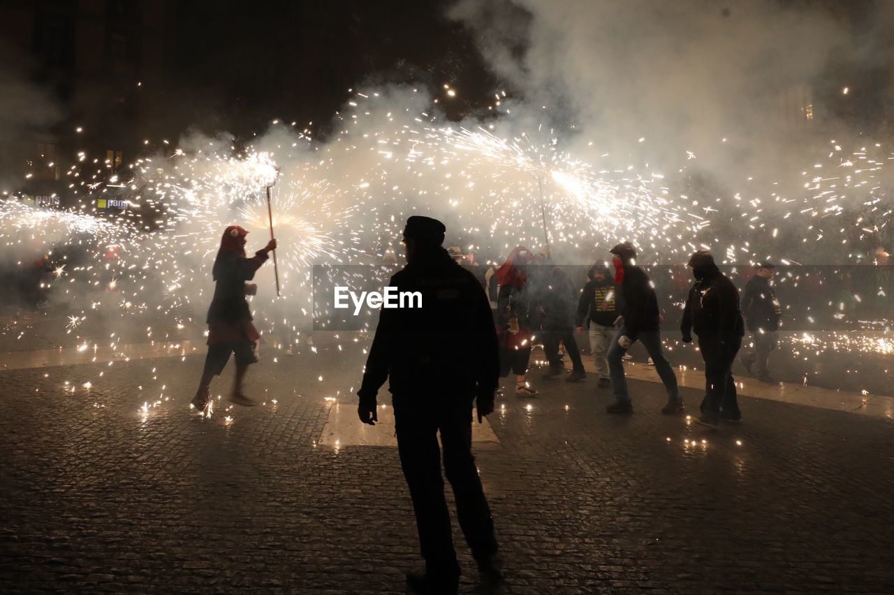 People enjoying firework display at night