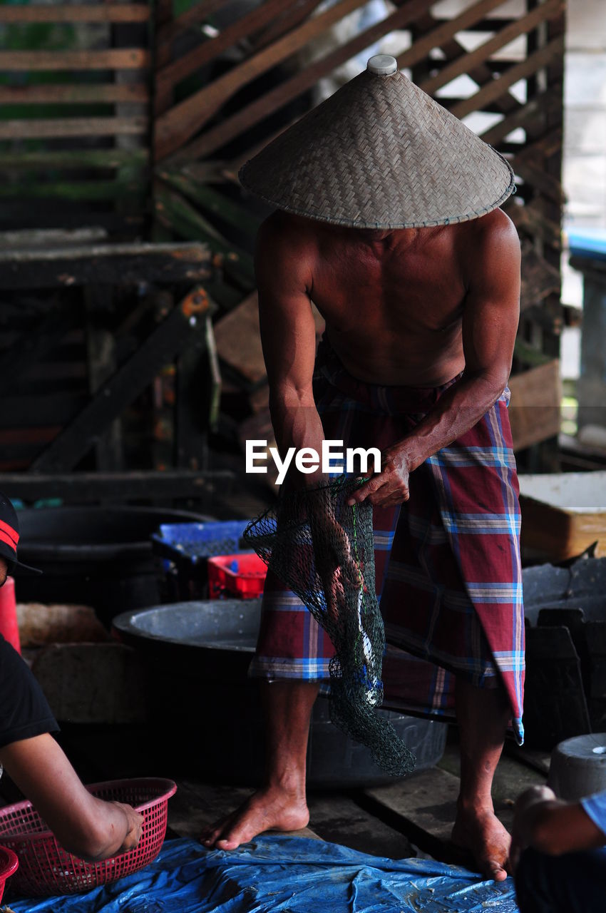 Fisherman in traditional market. midsection of man working