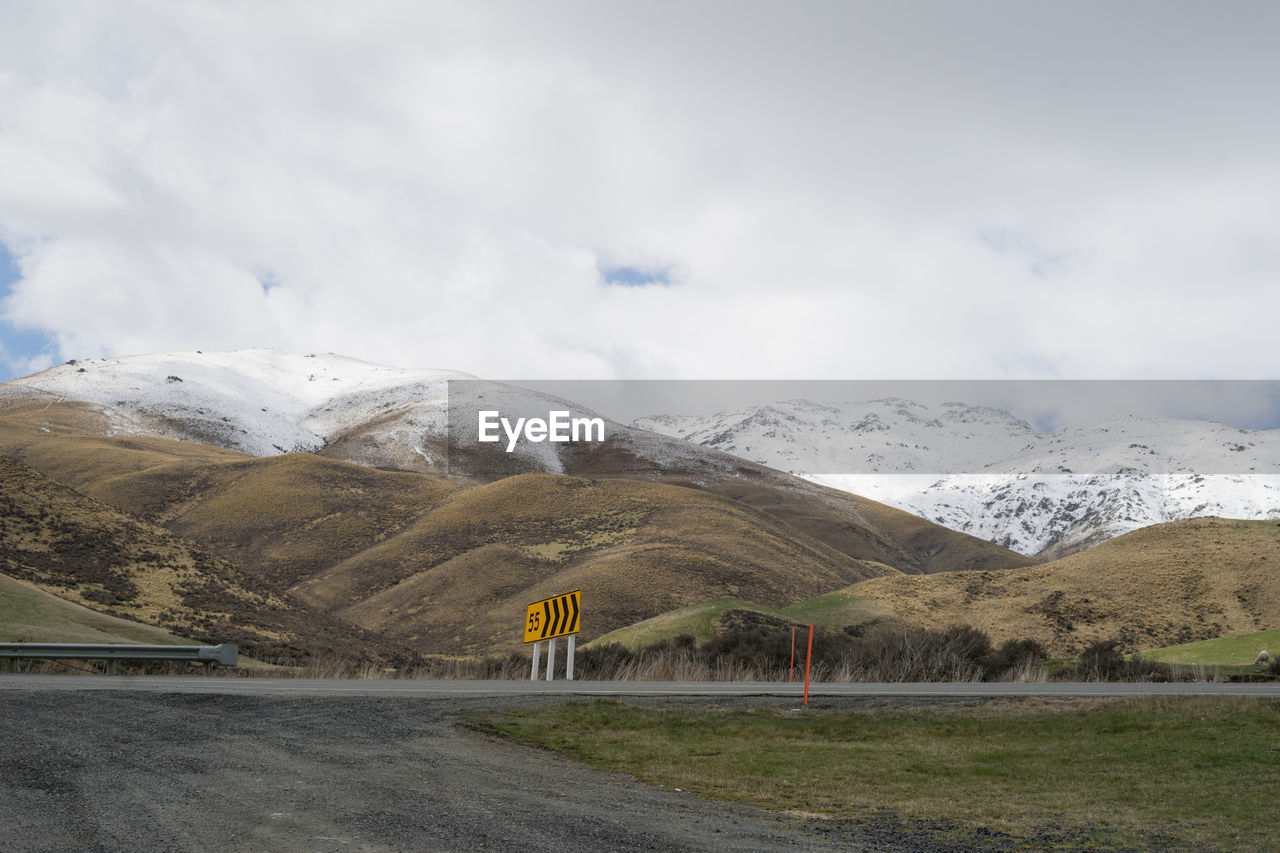 ROAD BY SNOWCAPPED MOUNTAIN AGAINST SKY