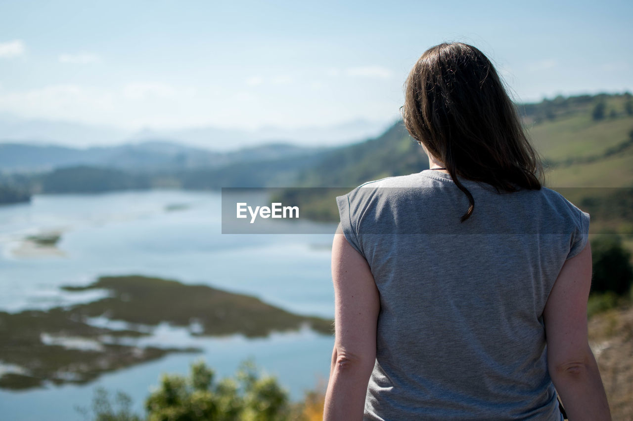 REAR VIEW OF MAN LOOKING AT MOUNTAIN