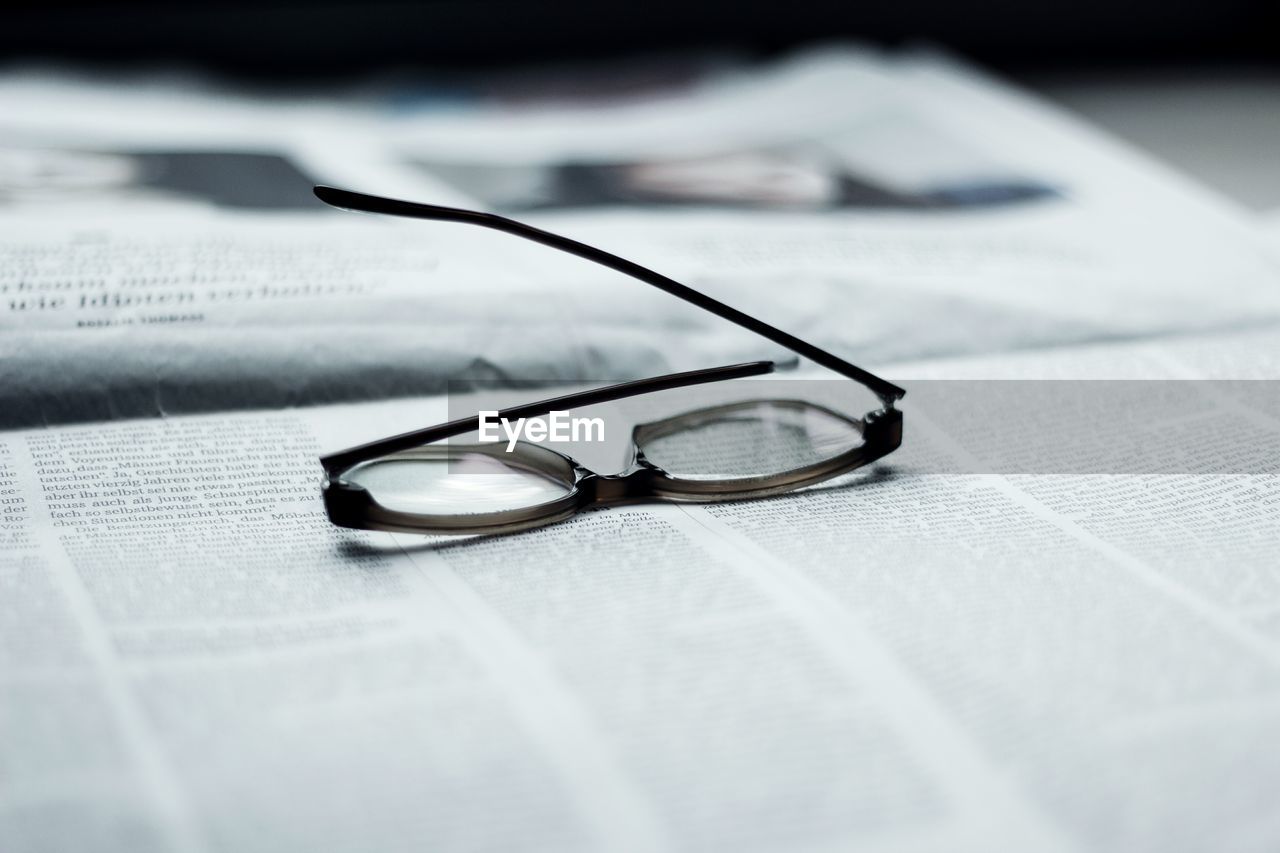 Close-up of eyeglasses on newspaper