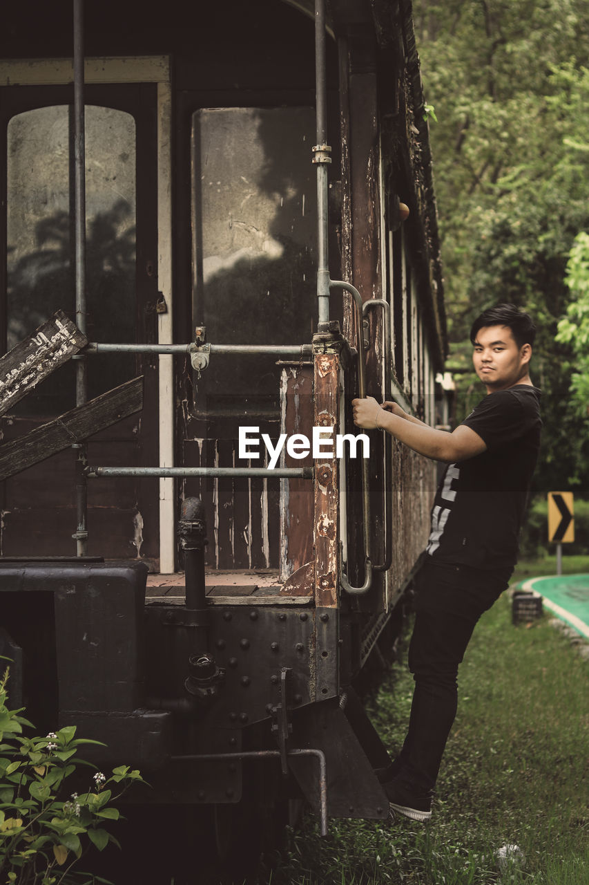 Portrait of young man hanging on train