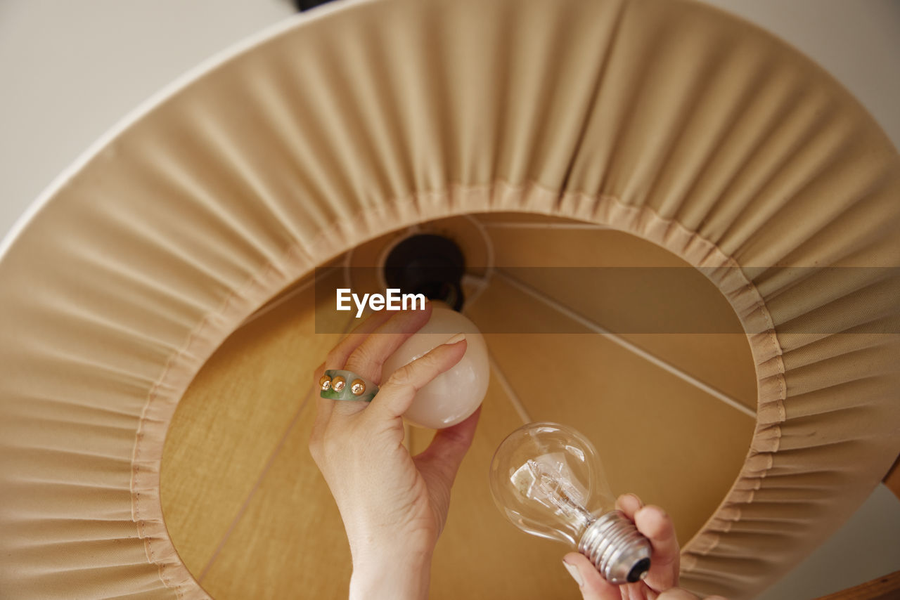 Woman's hands changing light bulb