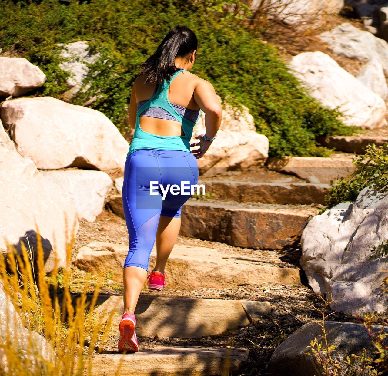 FULL LENGTH REAR VIEW OF WOMAN STANDING ON ROCKS