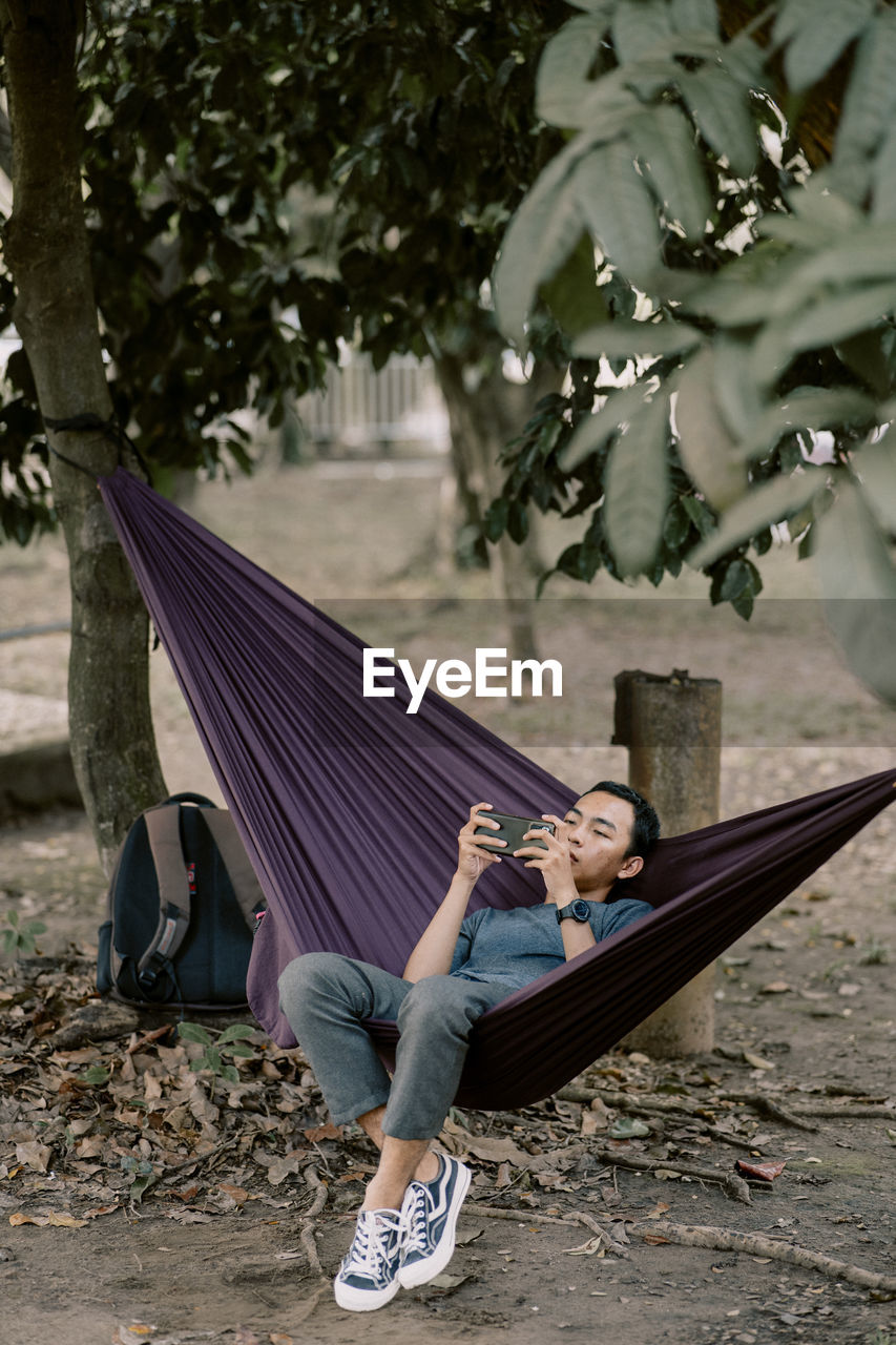hammock, full length, one person, relaxation, spring, adult, tree, leisure activity, plant, nature, lifestyles, lying down, casual clothing, day, men, outdoors, sitting, resting, lying on back, footwear, young adult, person, women, sleeping, clothing, leaf
