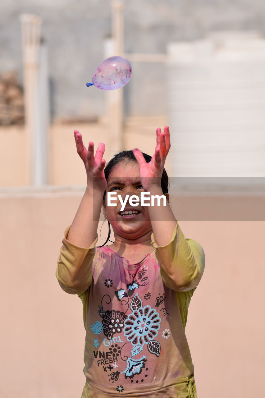 Girl playing with water bomb during holi