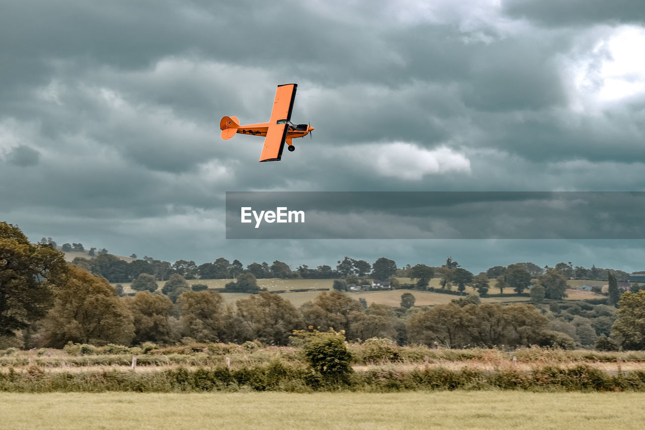 HELICOPTER FLYING OVER FIELD