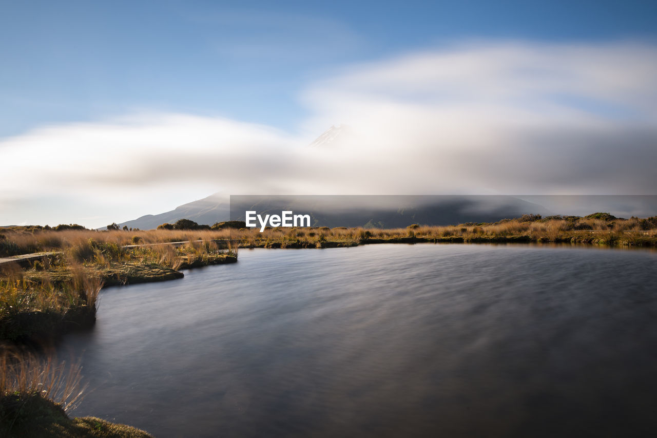 SCENIC VIEW OF LAKE BY MOUNTAINS AGAINST SKY