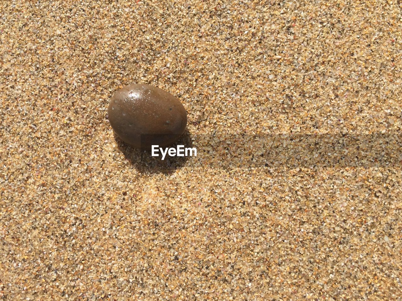 Close-up of smooth pebble on sand