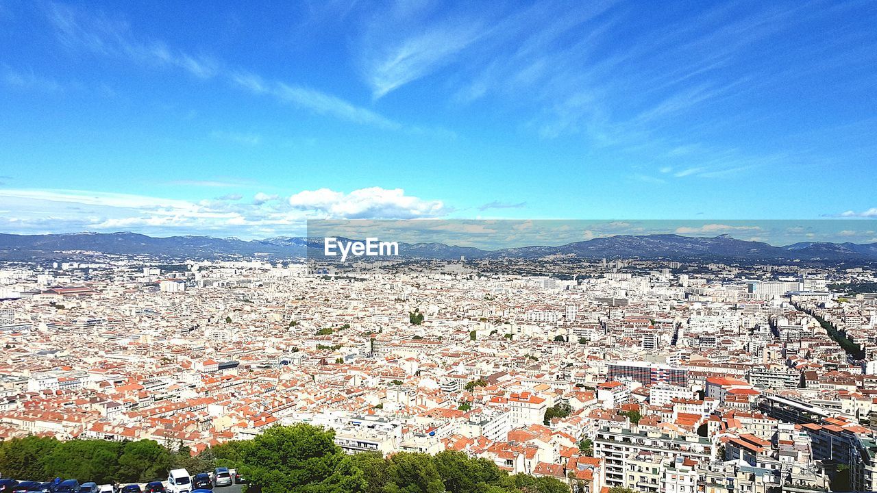 HIGH ANGLE VIEW OF HOUSES IN TOWN AGAINST SKY