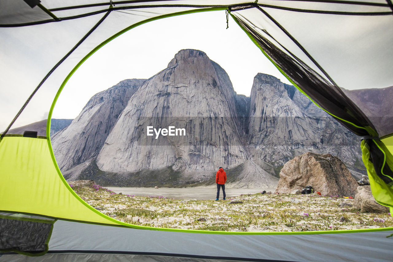 View of climber and mountain through open tent door.