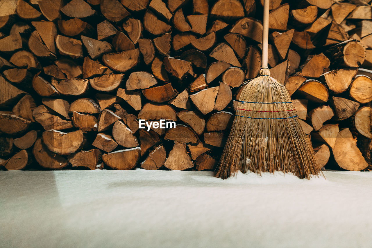 Broom and firewood by snow