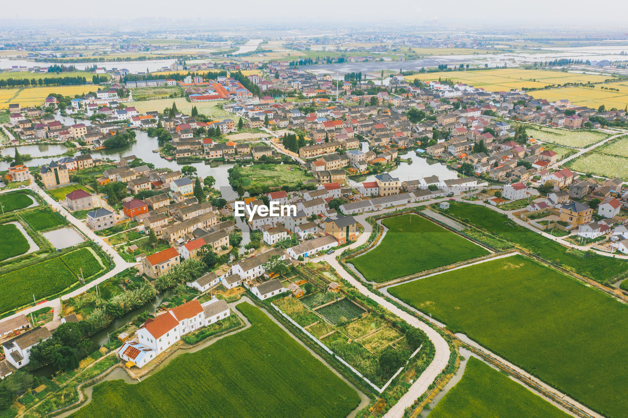 HIGH ANGLE VIEW OF BUILDINGS IN FIELD