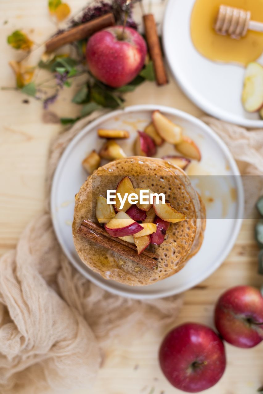 Directly above shot of pancakes and apples in plate on table