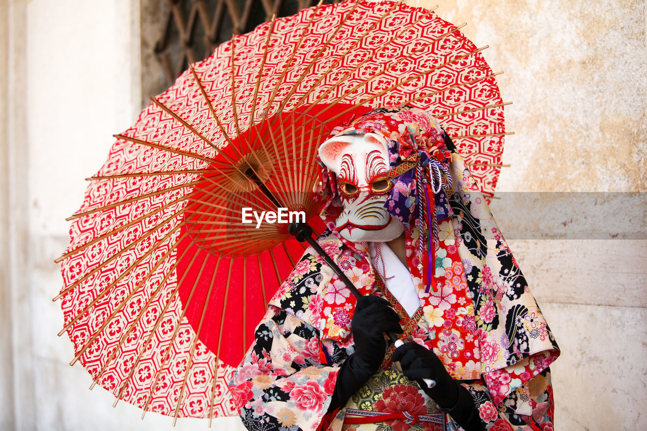 Person wearing venetian mask 