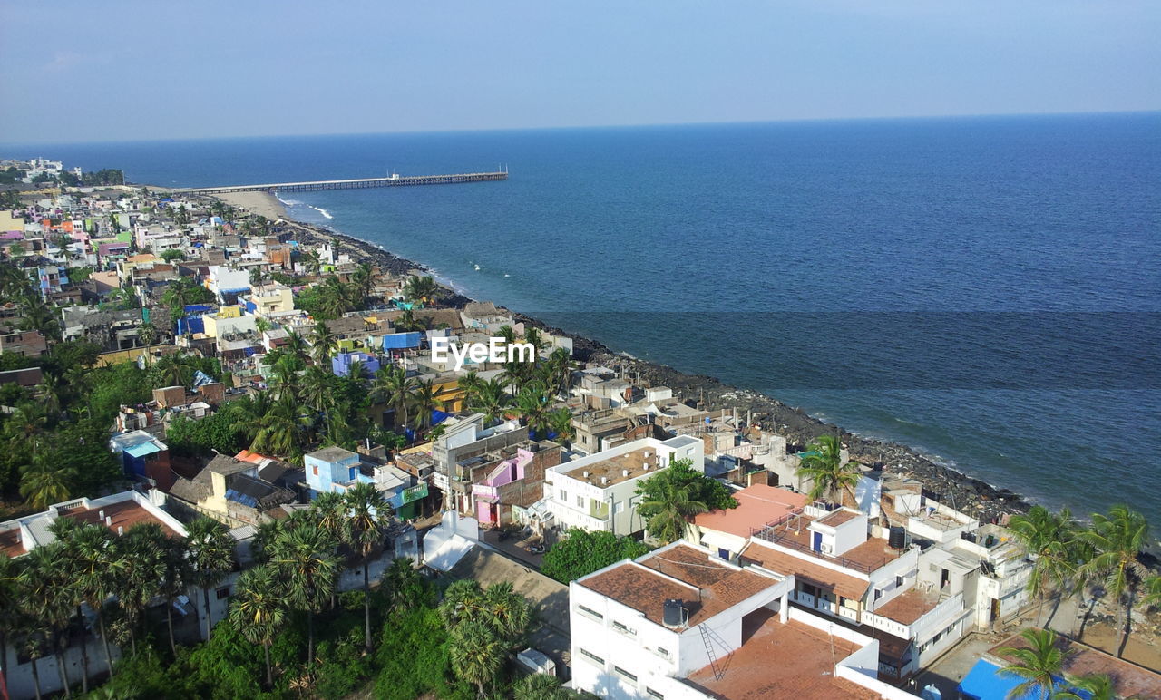 High angle view of townscape by sea against sky