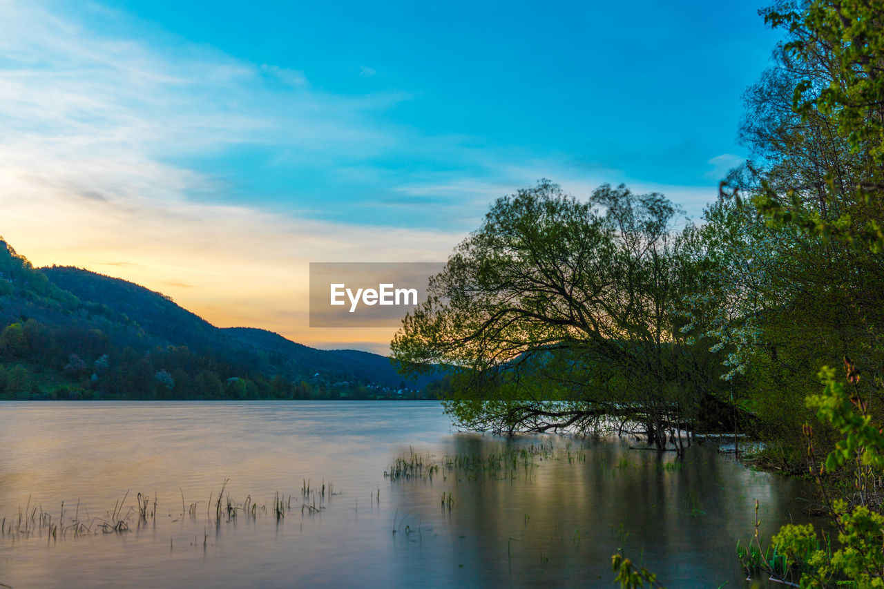 Scenic view of lake against sky during sunset