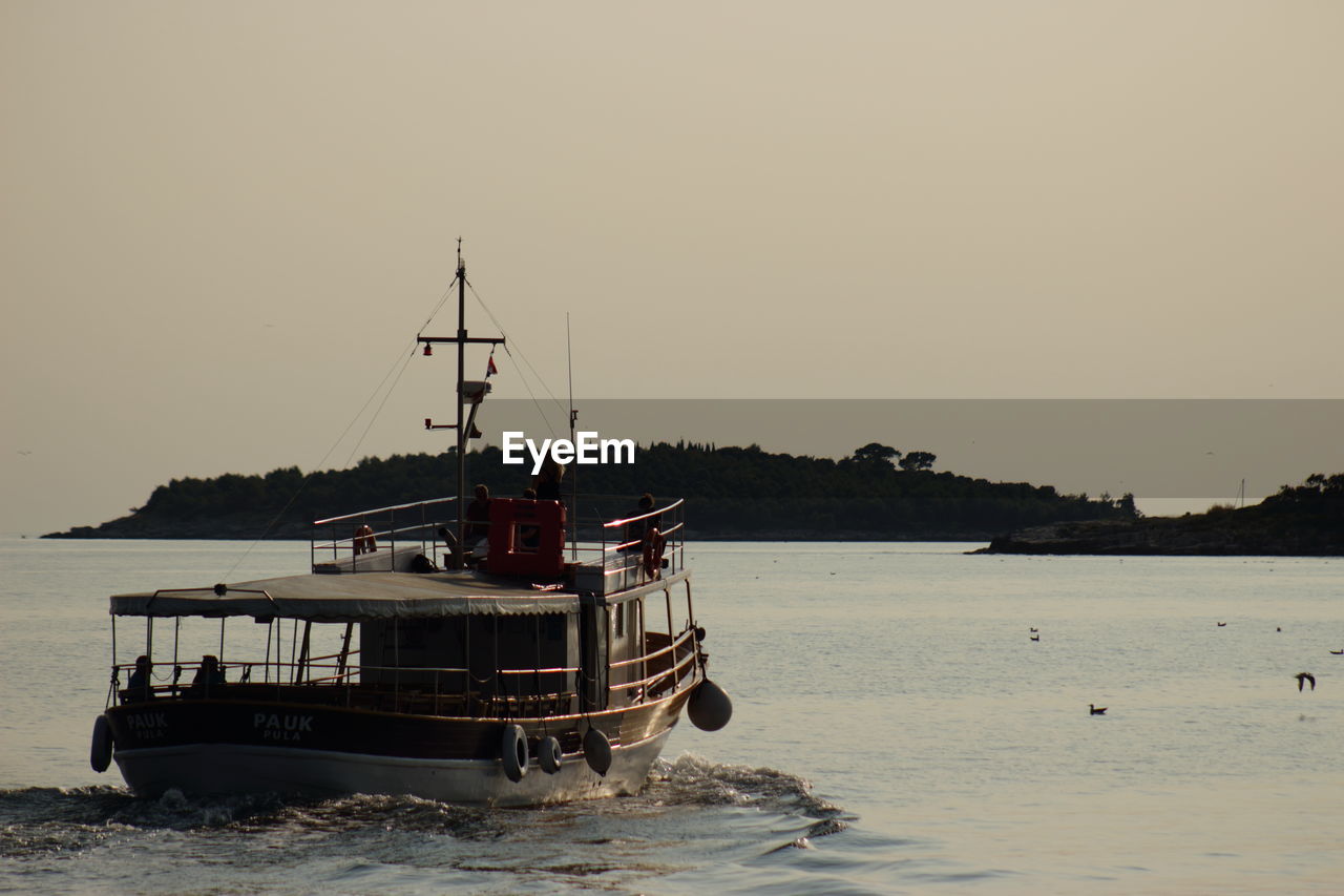 Boat moored on sea against clear sky