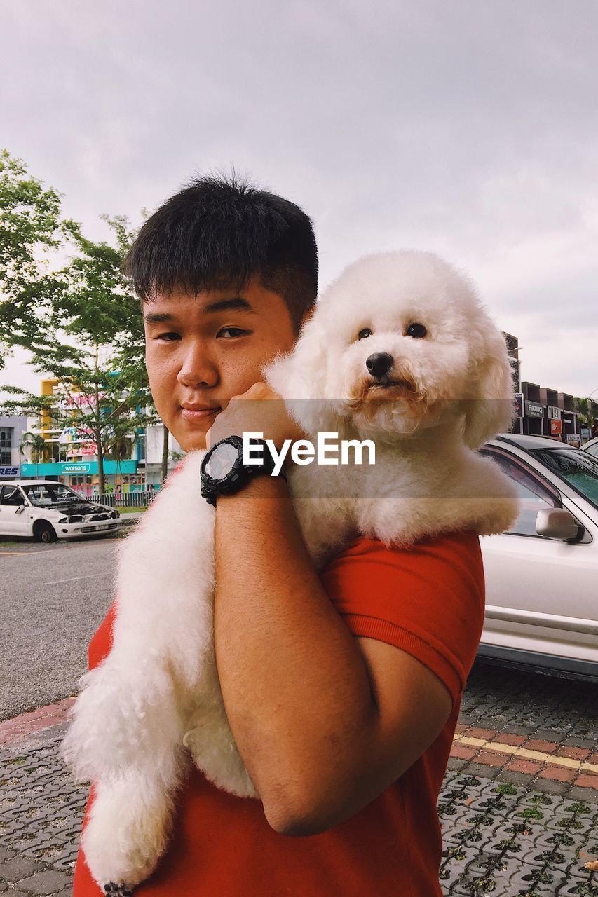 Portrait of smiling man with dog in city