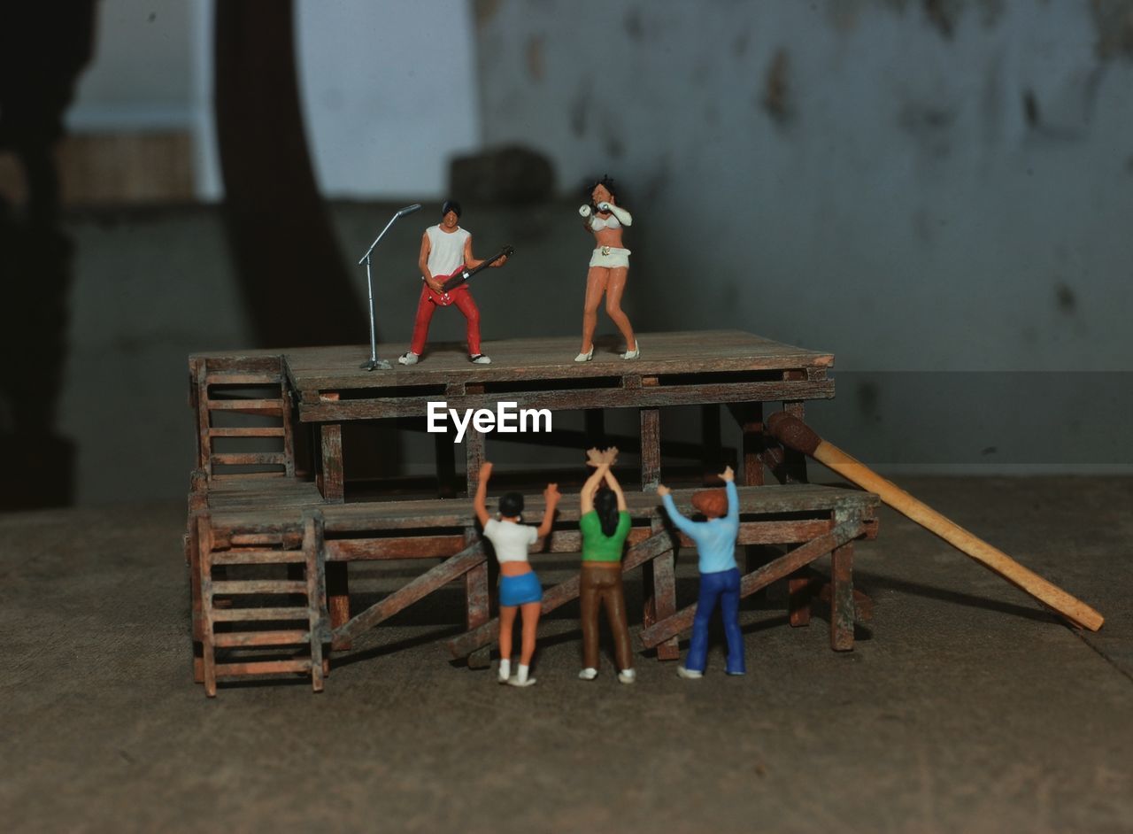Figurines audience cheering to musician performing on stage
