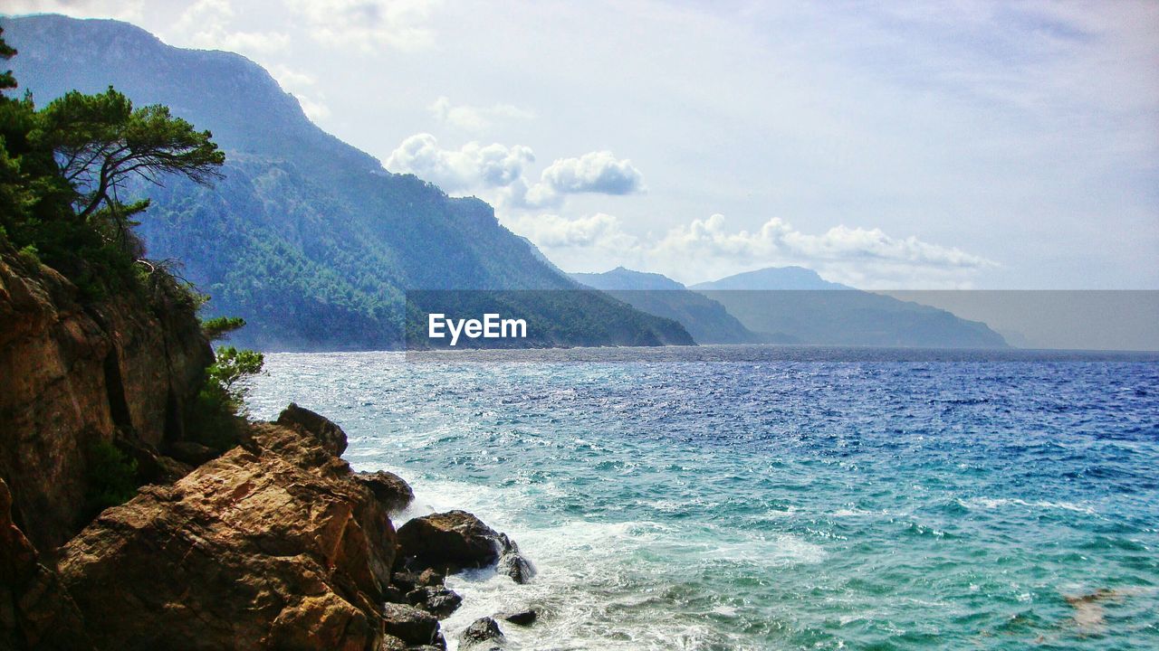 Scenic view of sea and mountain against sky