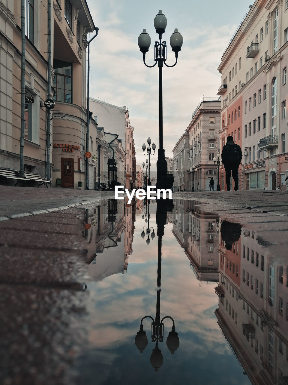 Reflection of buildings in puddle on street