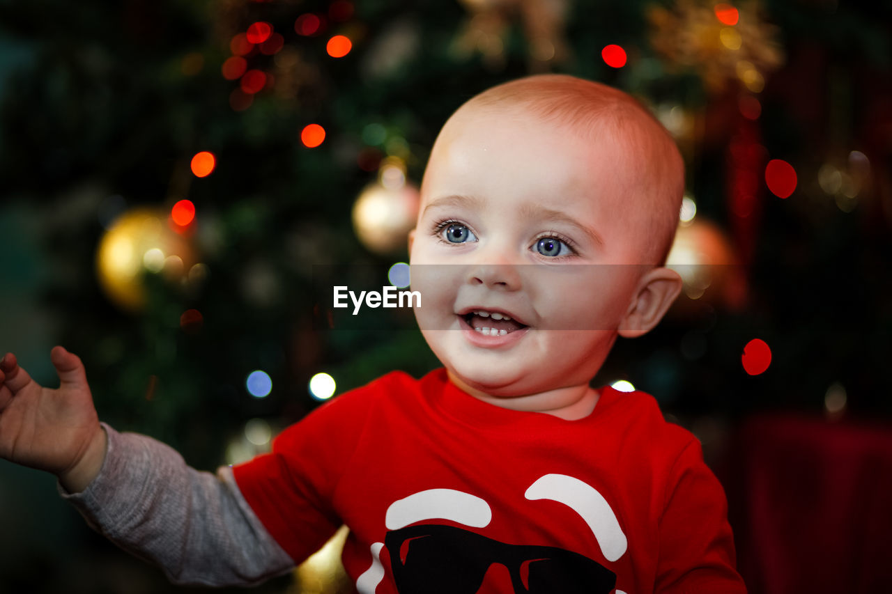 Portrait of smiling boy with christmas tree