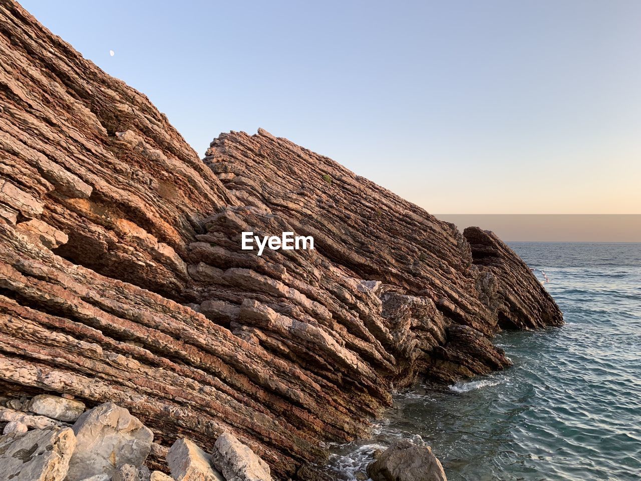 SCENIC VIEW OF ROCK FORMATION IN SEA AGAINST CLEAR SKY